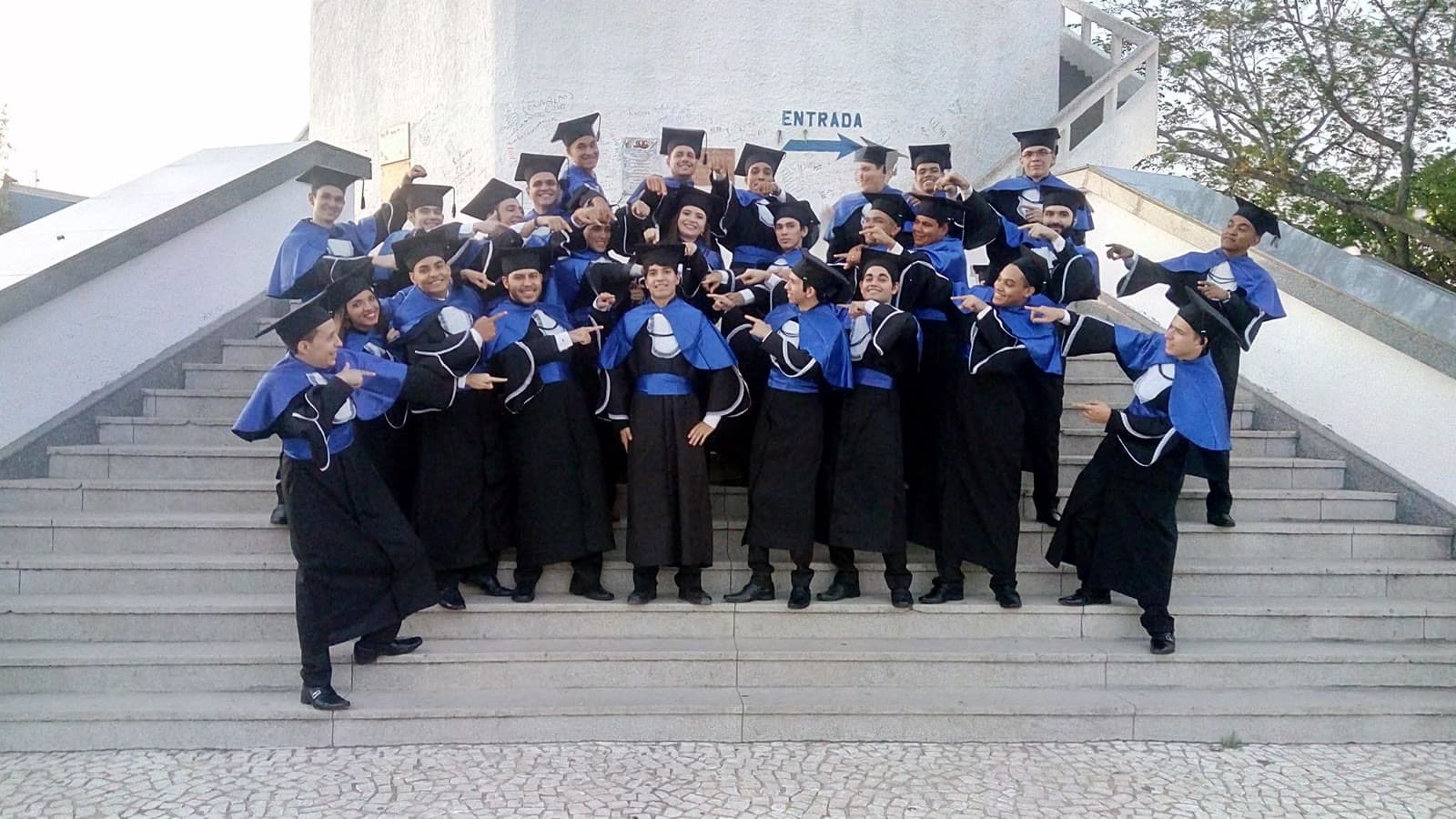 Turma de formandos de beca na escadaria