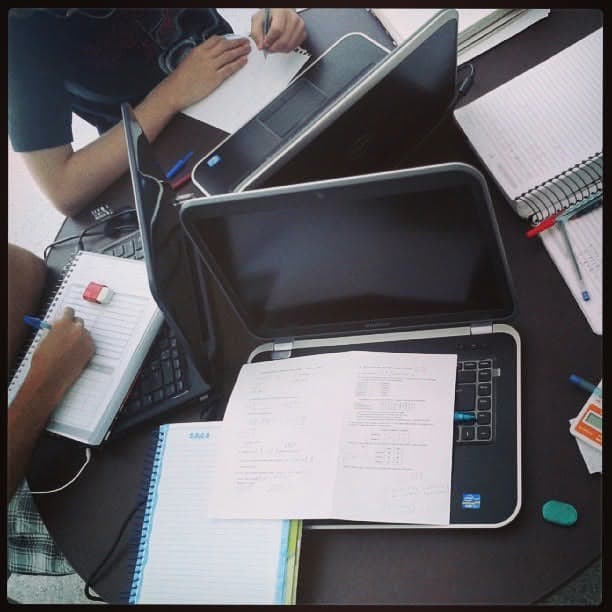 Mesa de estudos com notebook, caderno e anotações